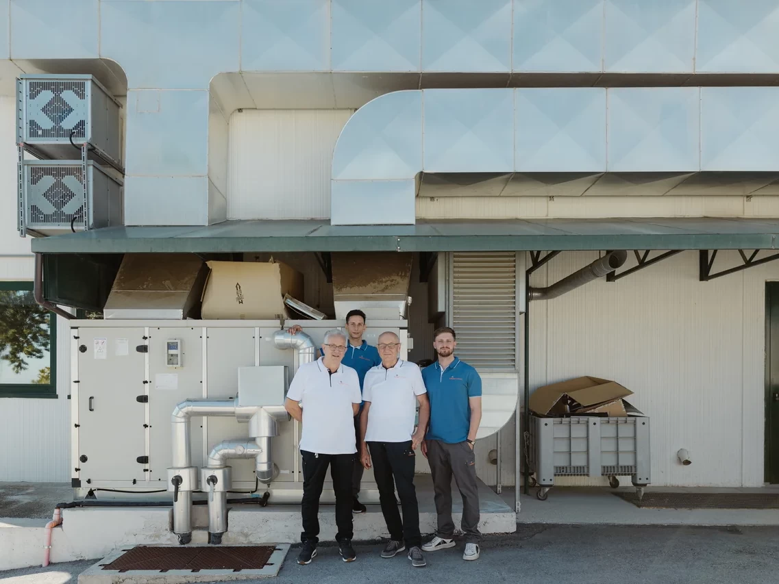 Quattro persone del gruppo di Palmieri Impianti davanti a un&rsquo;installazione industriale